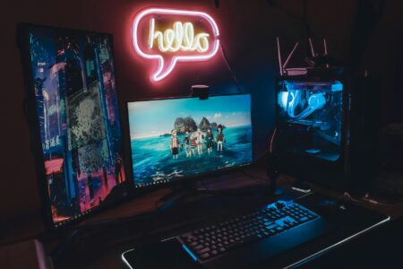 Computer gaming setup with multiple monitors displaying game interface