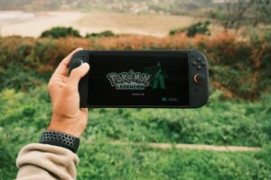 Modern gaming handheld device being held in hands showing screen interface