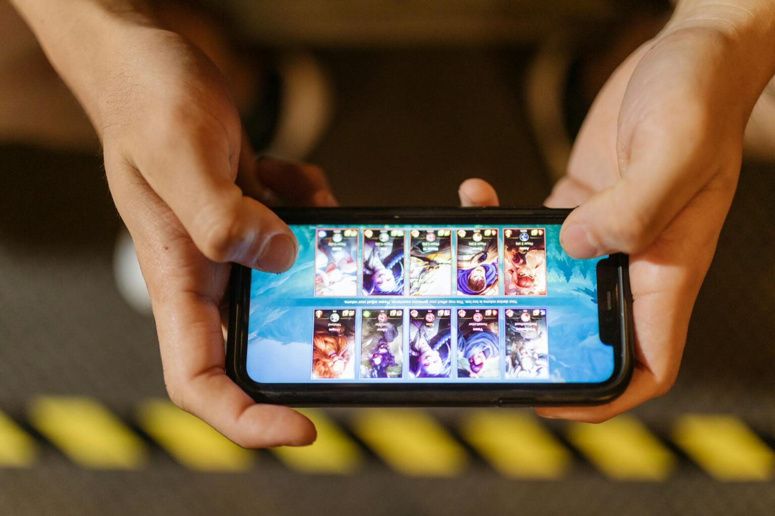 Person playing mobile game on smartphone with gaming content on screen