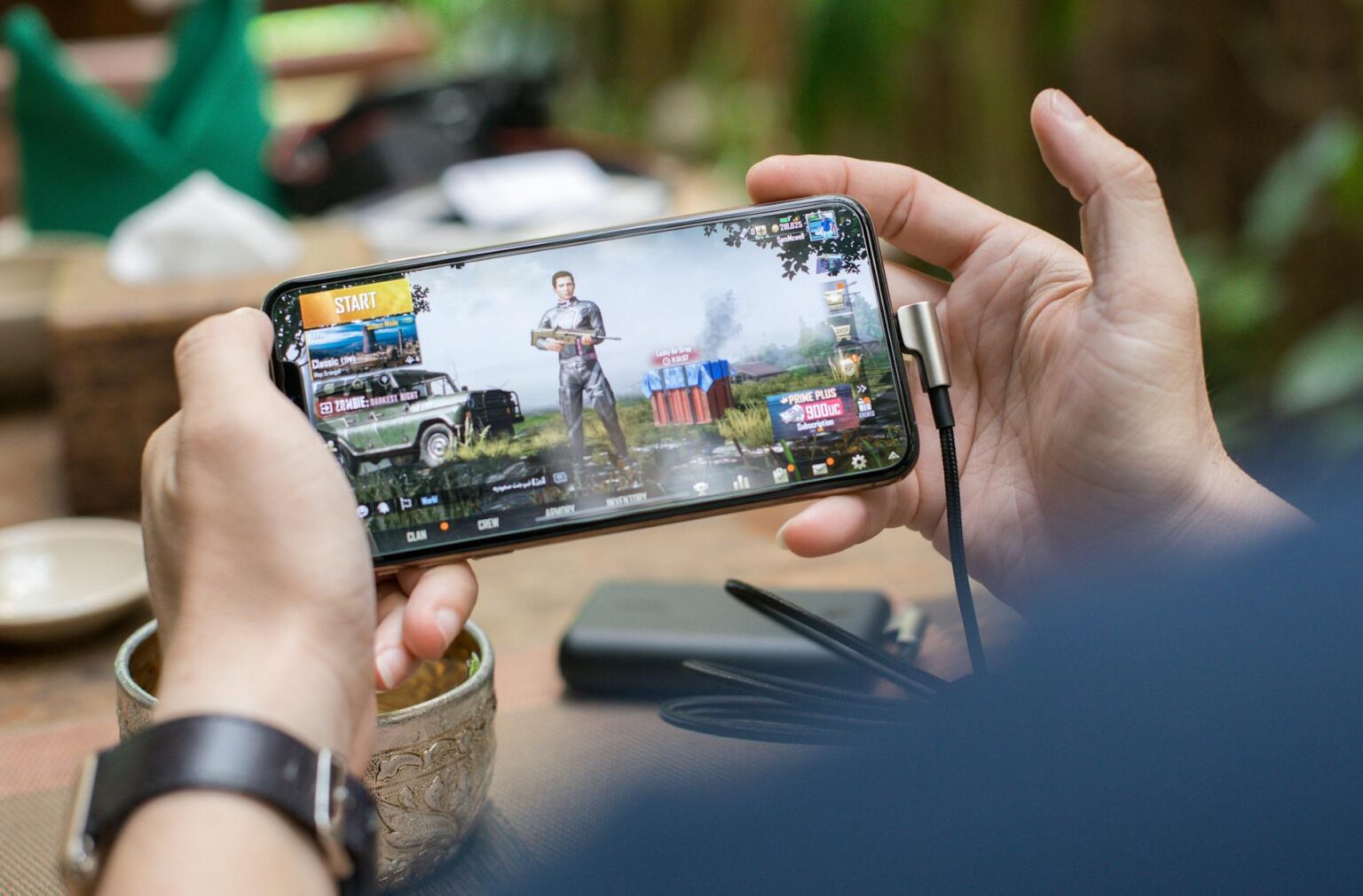Why Animal Crossing Mobile Finally Launched Without Microtransactions Person playing mobile game on smartphone with colorful interface visible on screen