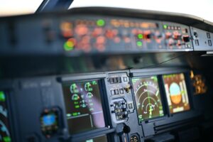 Professional flight simulator cockpit setup with multiple screens and realistic controls for pilot training