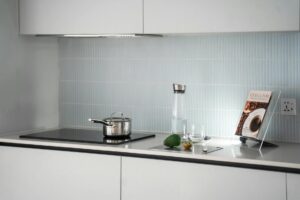 Open cookbook on kitchen counter with cooking ingredients and utensils around it