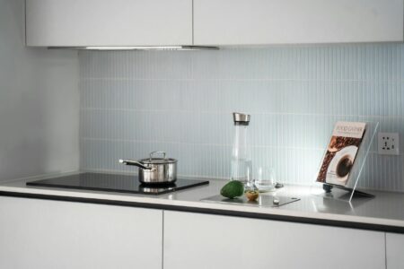 Open cookbook on kitchen counter with cooking ingredients and utensils around it