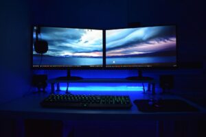 Gaming computer setup with multiple monitors displaying PC gaming interface