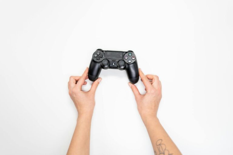 Portable gaming device being held in hands showing screen and controls