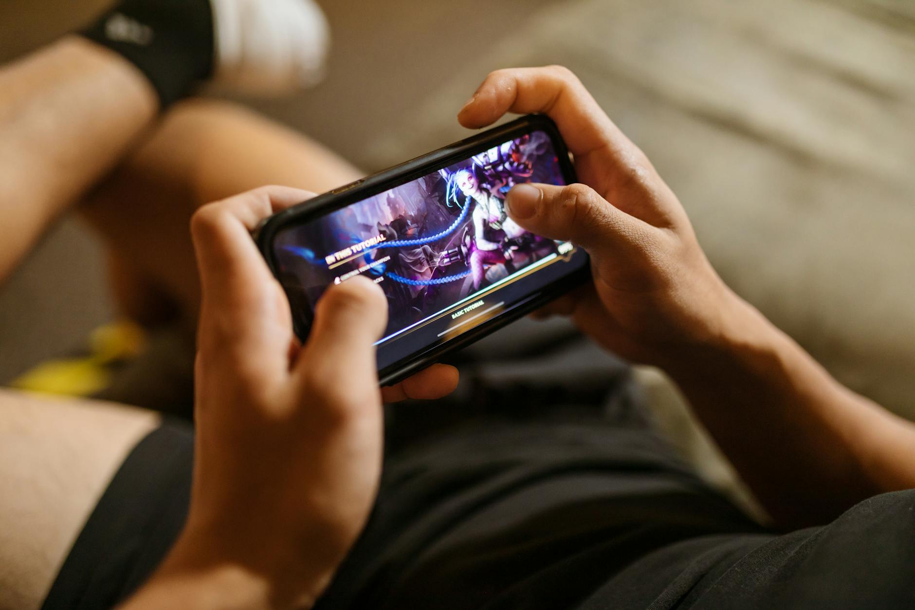 Person holding smartphone displaying mobile gaming interface