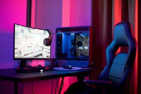 Gaming computer setup with multiple monitors showing Steam interface and game library