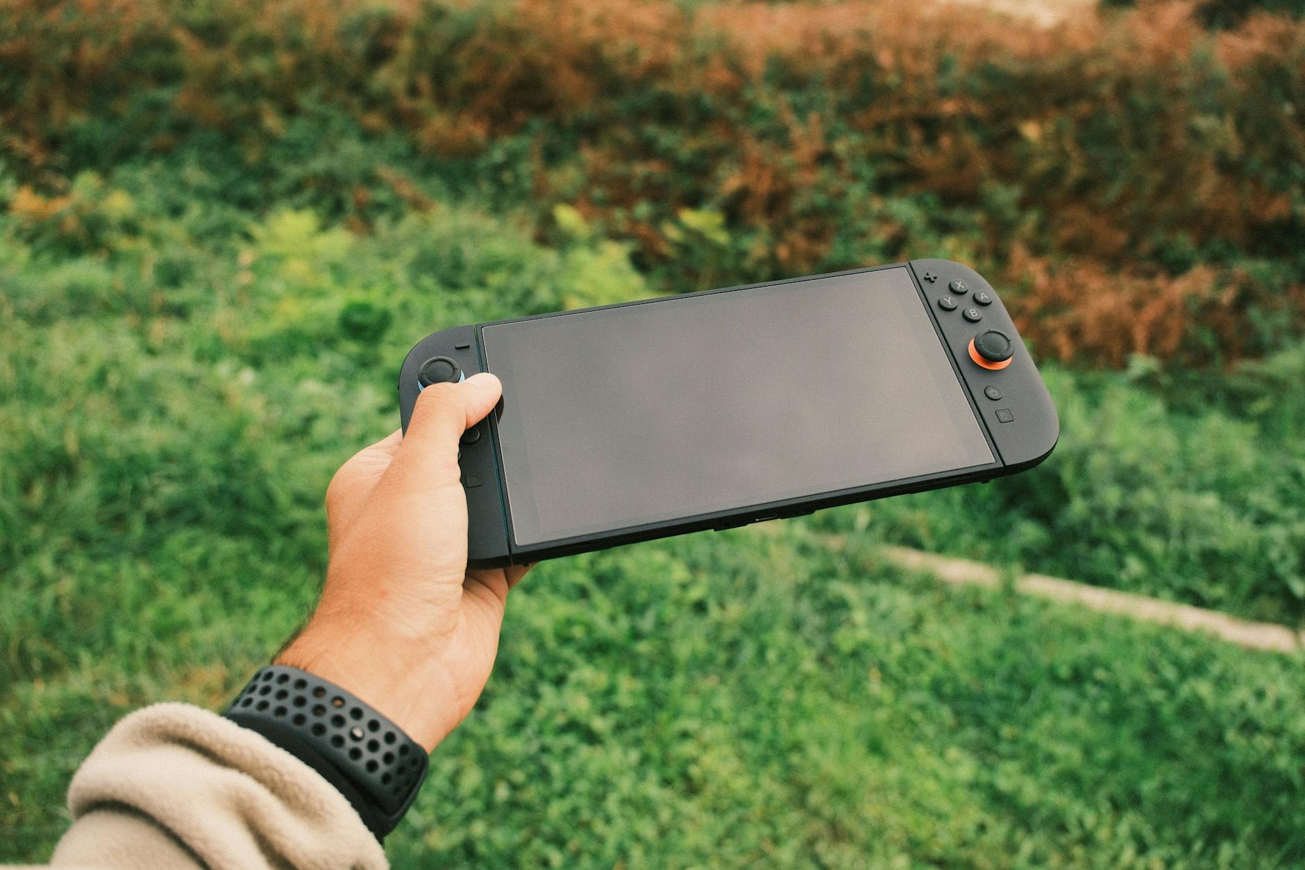 Modern handheld gaming device on dark surface showing competitive gaming market