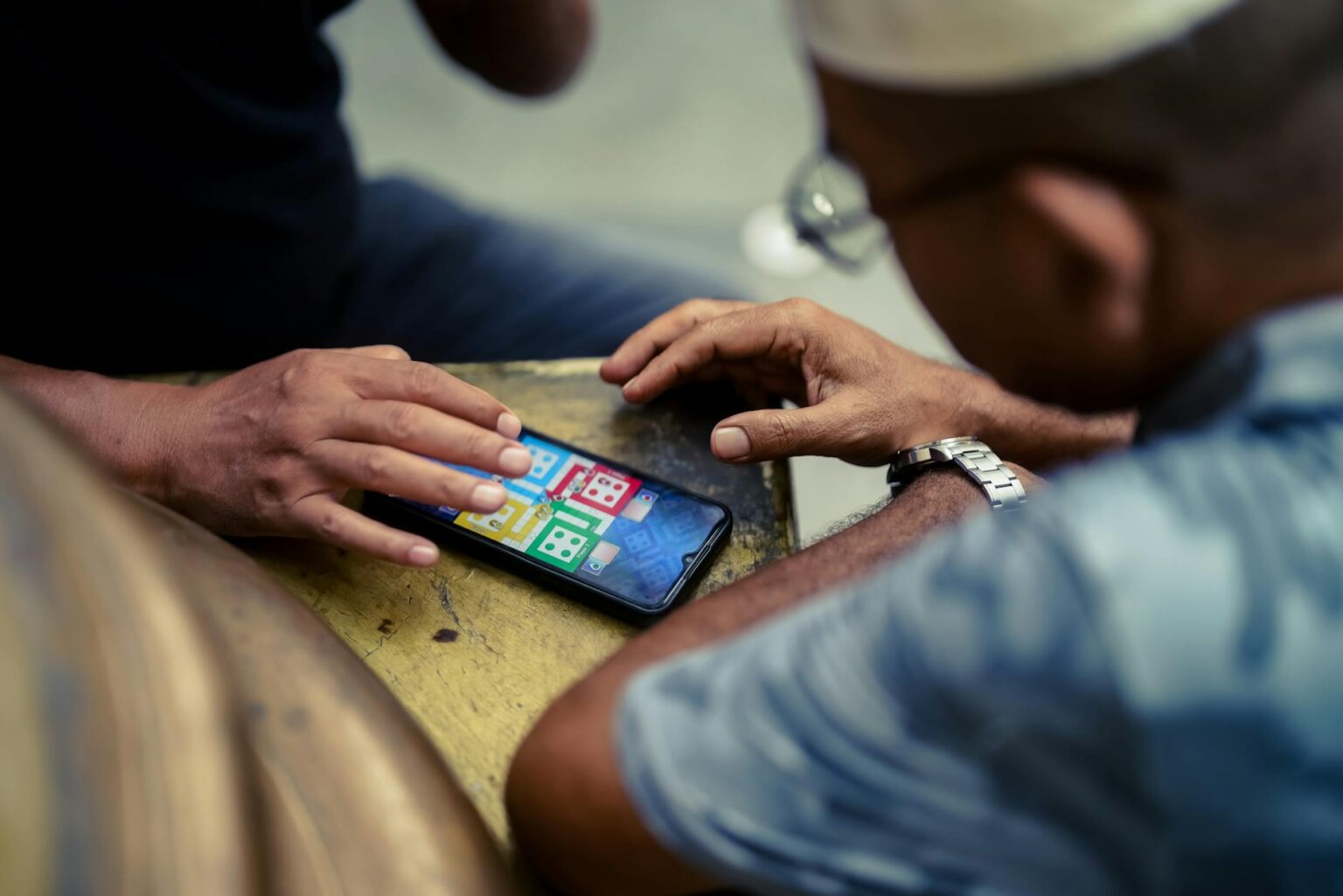 Person playing mobile games on smartphone with colorful game interface visible on screen