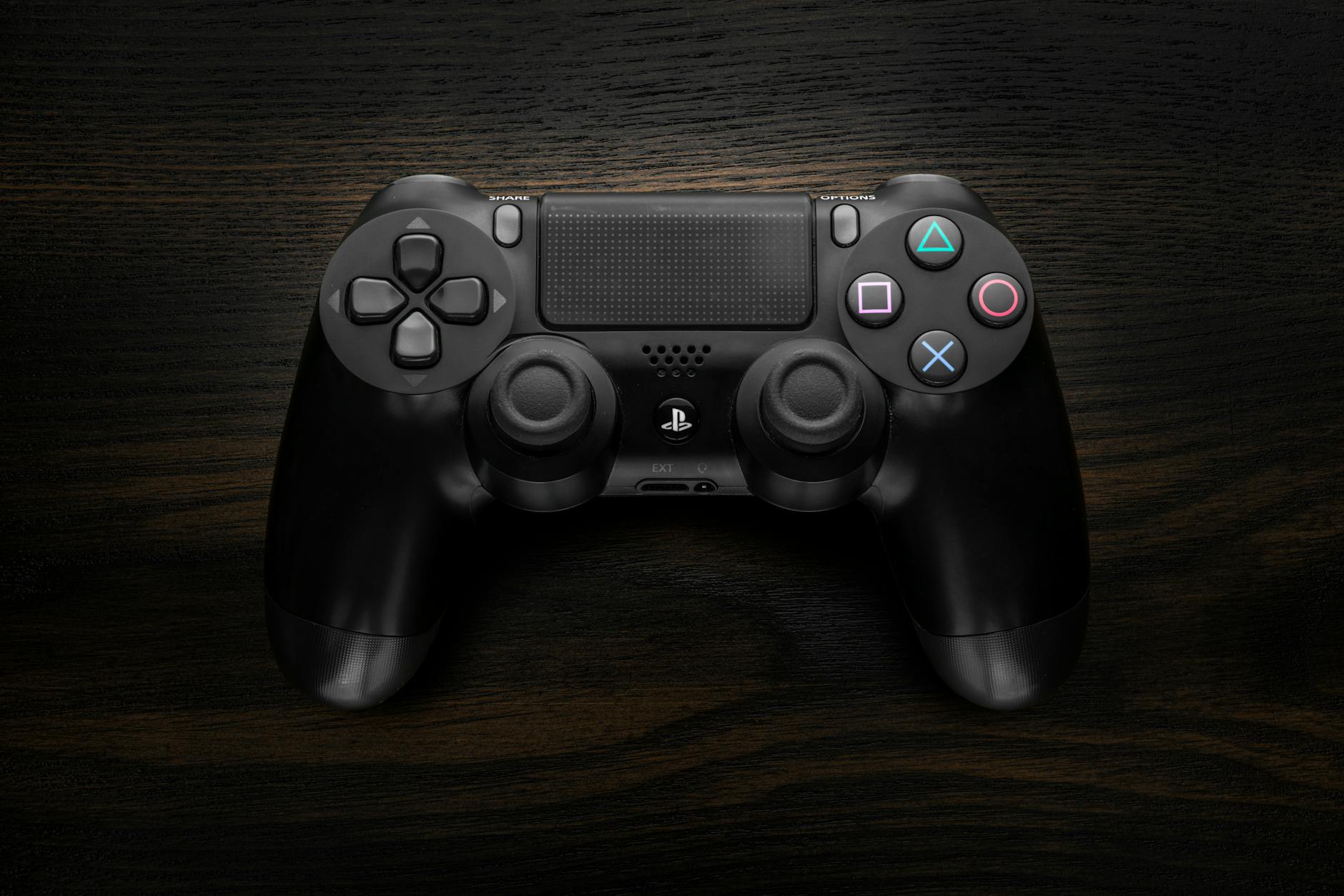 Modern video game controller on wooden surface representing gaming industry development