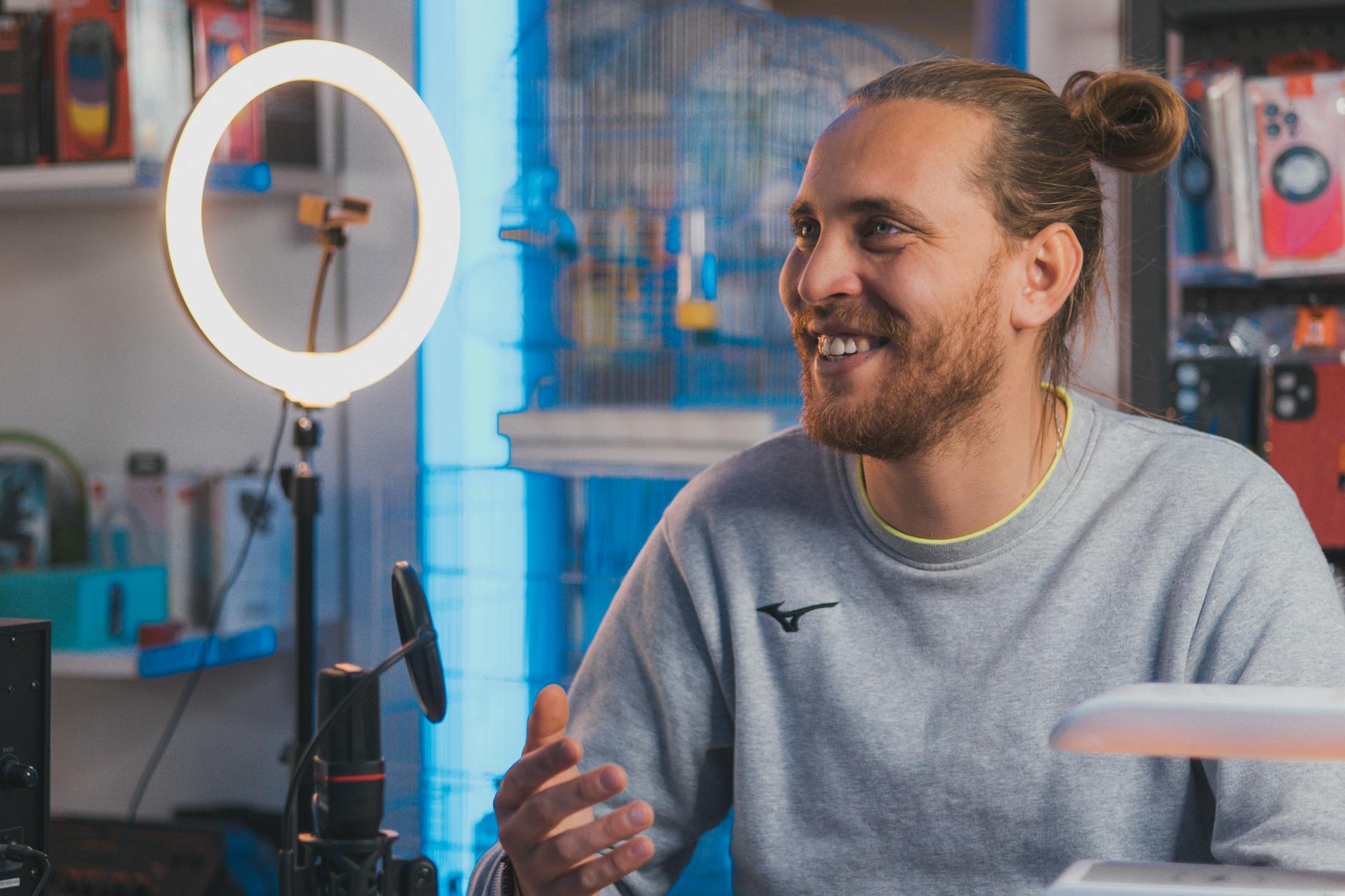 Young content creator filming video with smartphone in modern setup