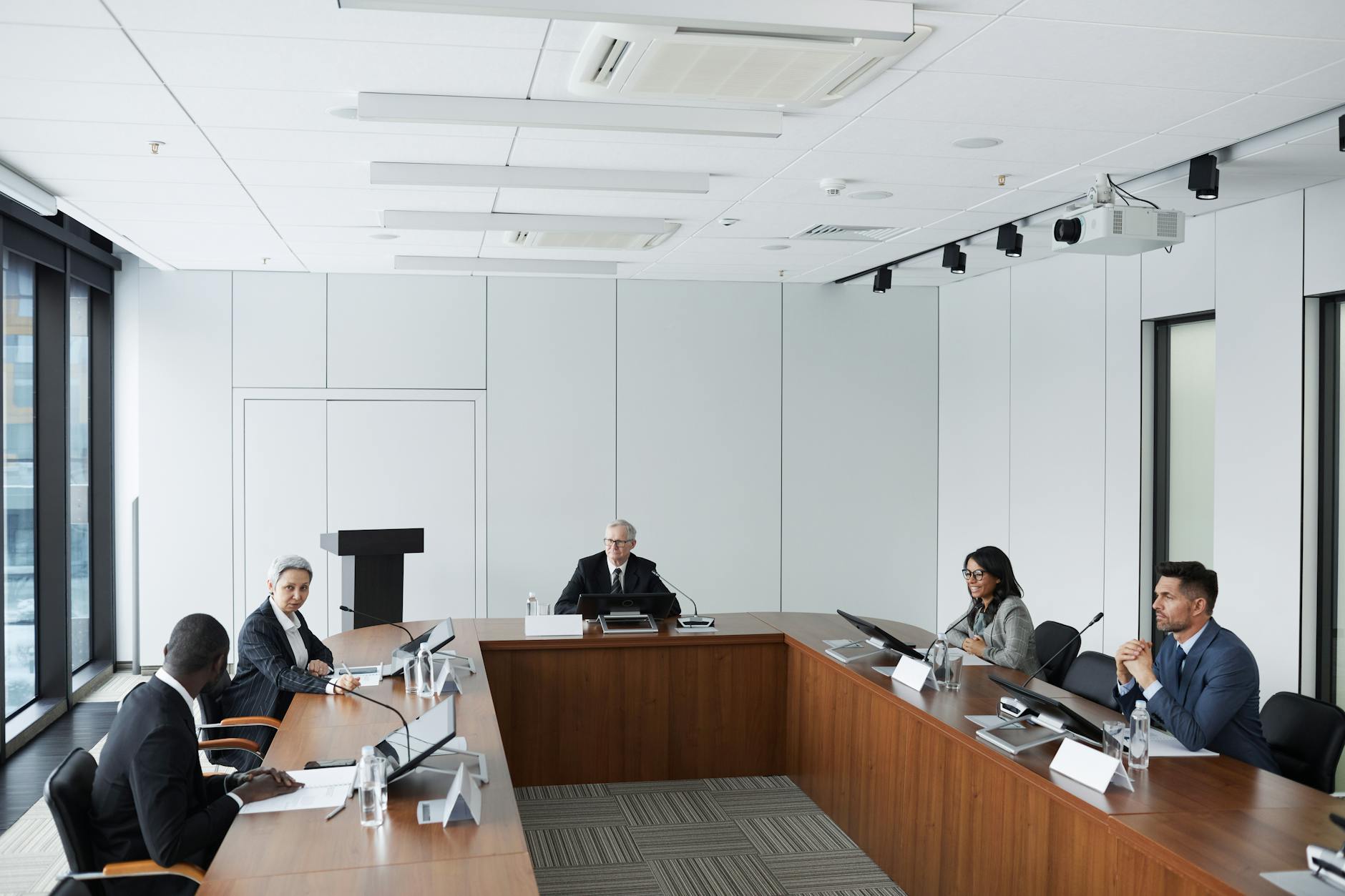 Business professionals in meeting room discussing strategy and charts on wall