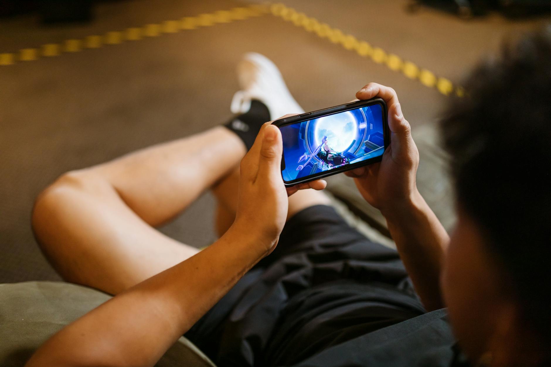 Person playing mobile game on smartphone with focused expression