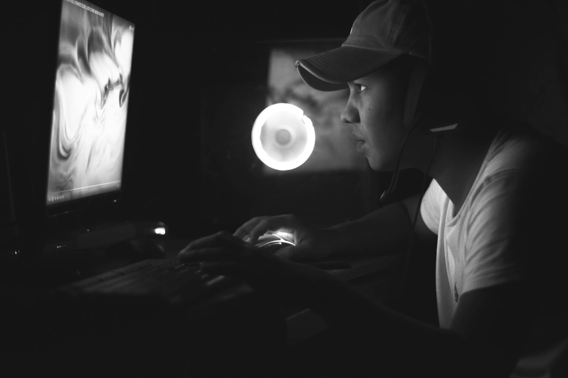 Person streaming and commentating at computer setup
