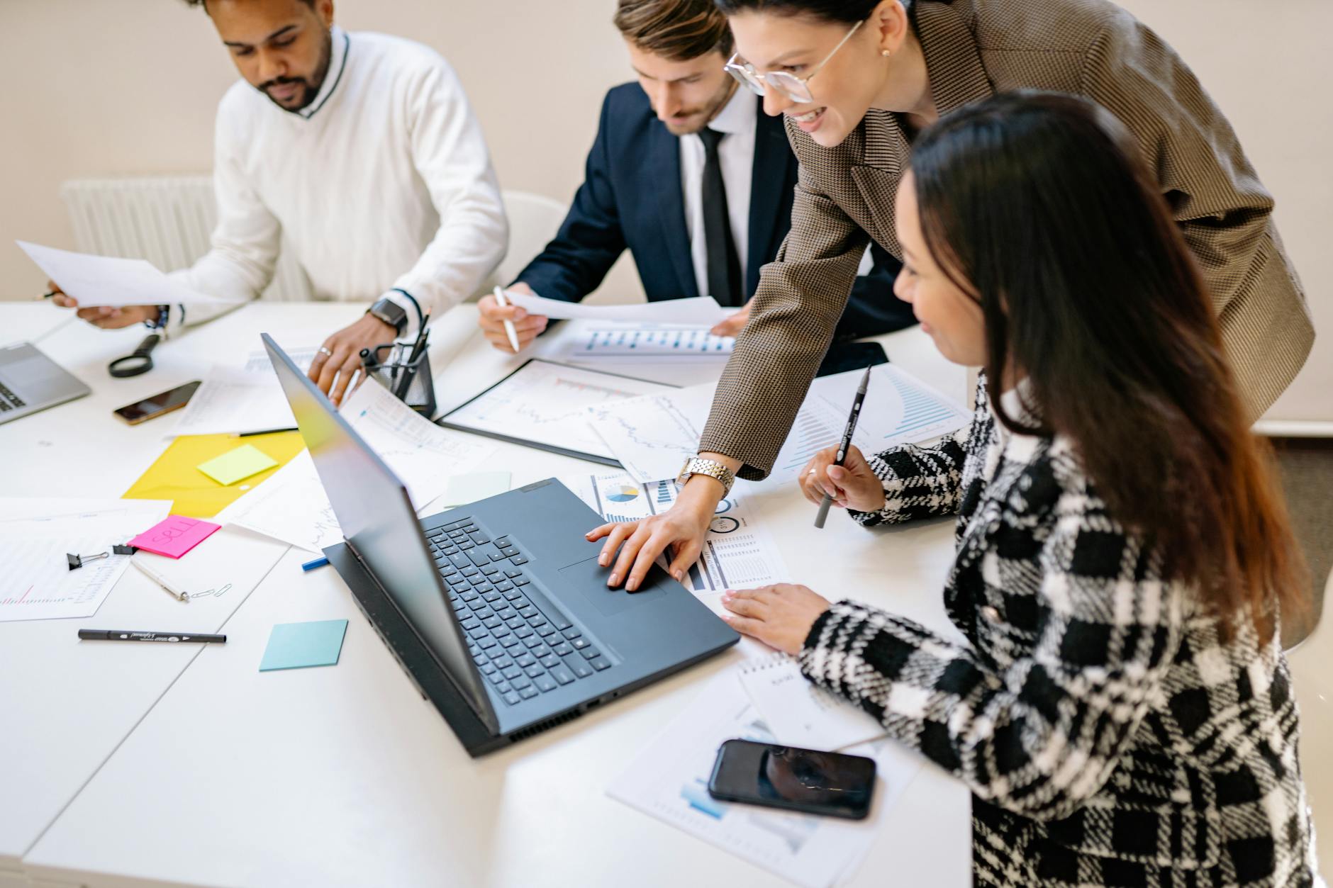 Group of people collaborating around computer workstations in modern office