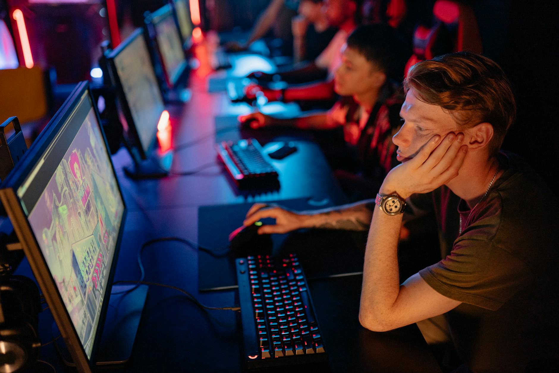 Professional esports arena with large screens and competitor gaming stations under bright stage lighting
