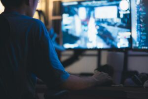 A game developer working at a desk in a modern studio environment