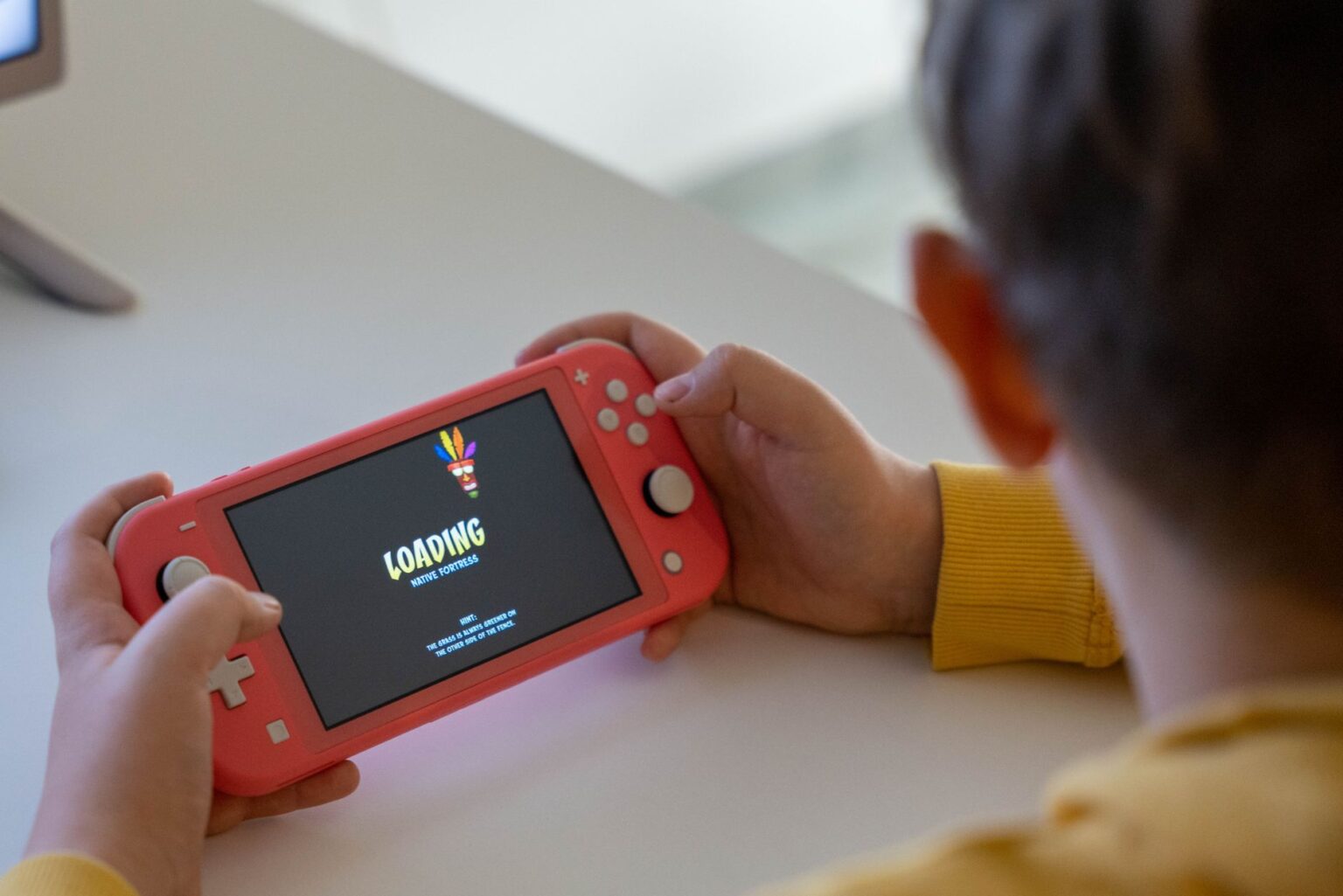Person playing a handheld gaming console on a couch