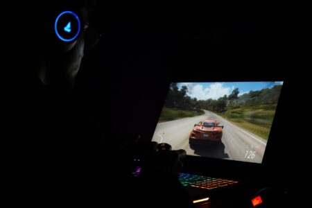 A gaming laptop displaying a Steam store page on a desk