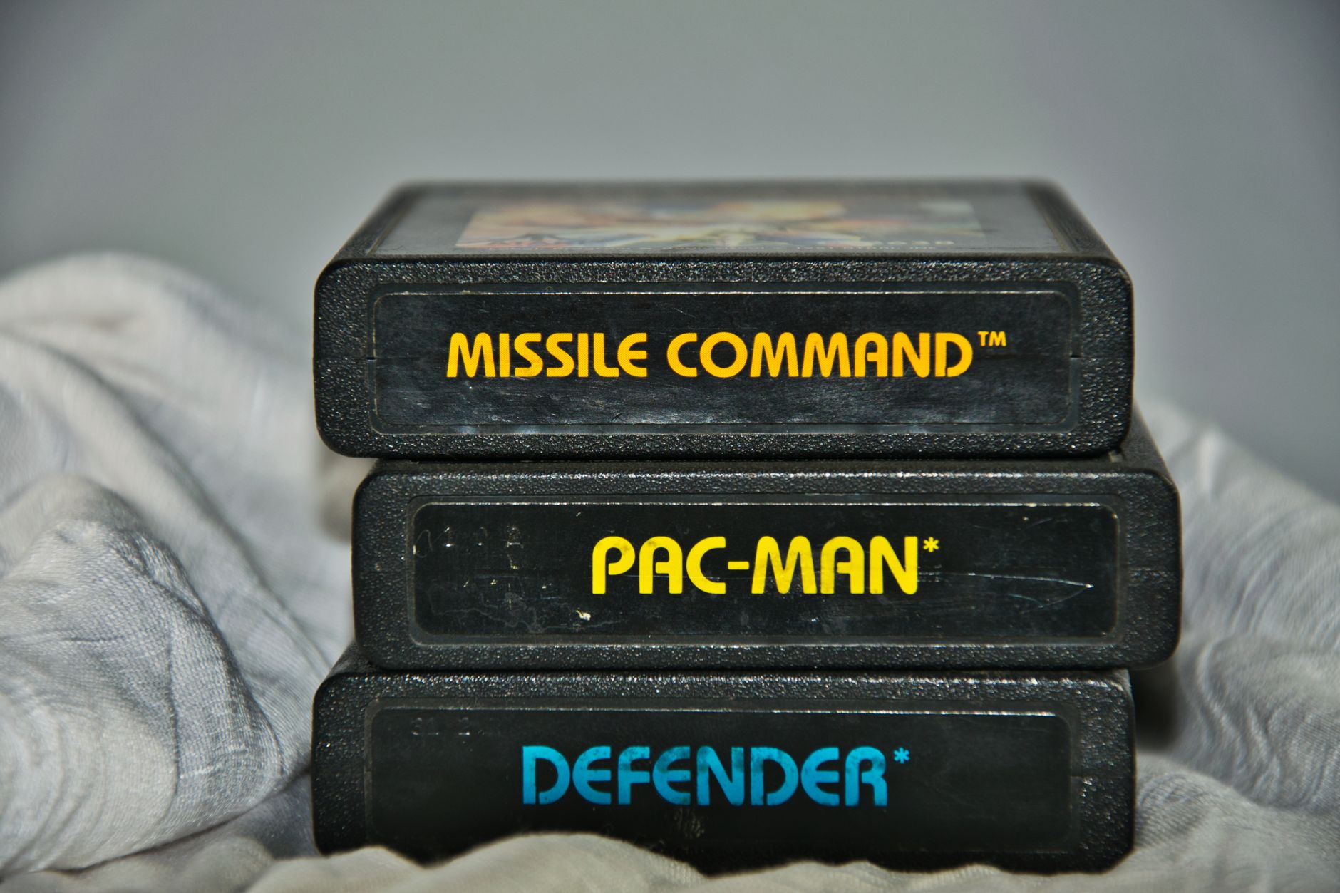A physical video game cartridge held between two fingers, representing physical game ownership concerns