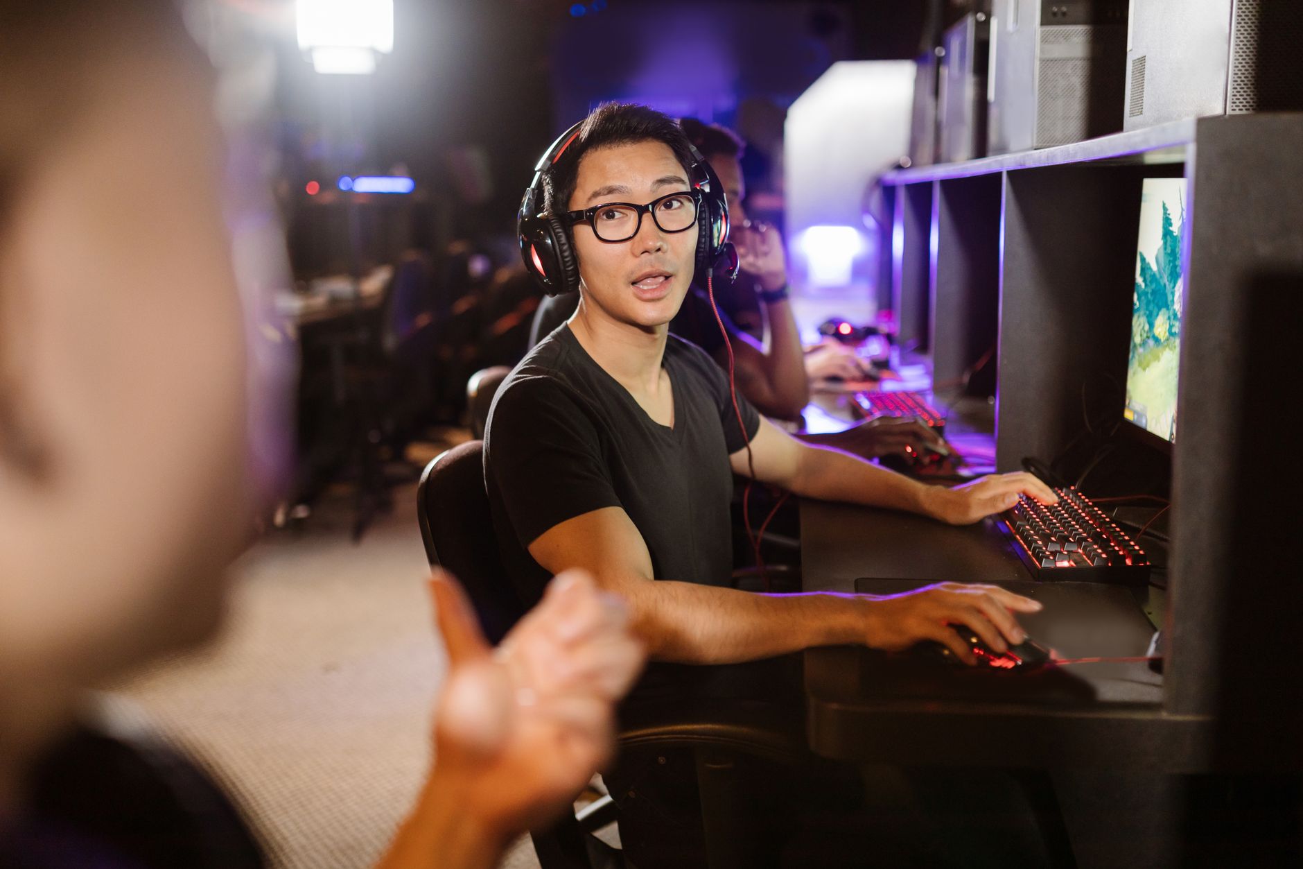 Group of people engaged in online discussion around gaming screens
