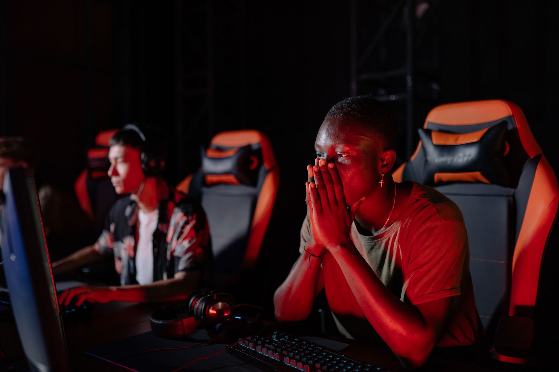 A person sitting at a gaming setup looking disengaged, representing fan frustration during a long wait