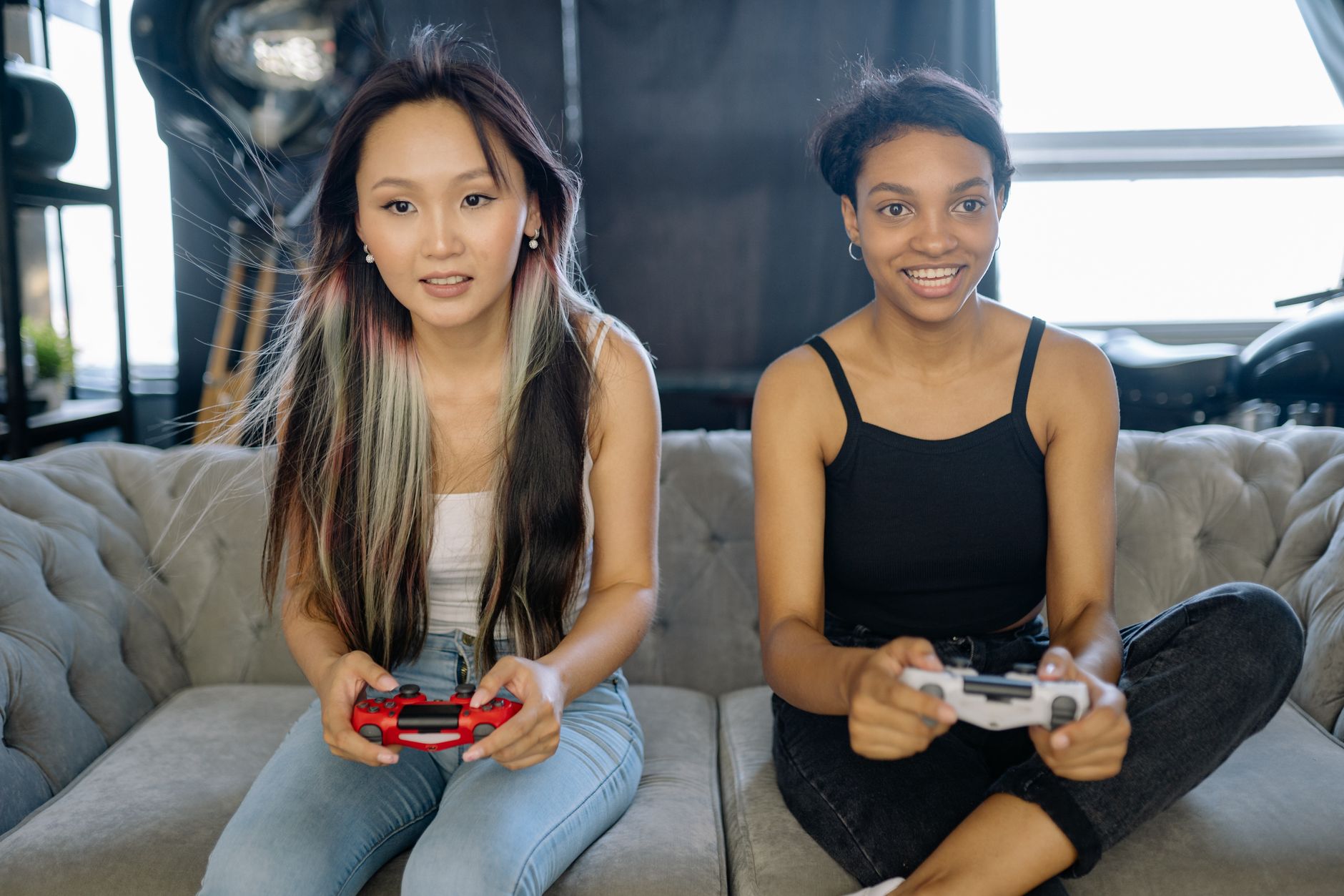 A group of friends sitting together playing video games on a couch