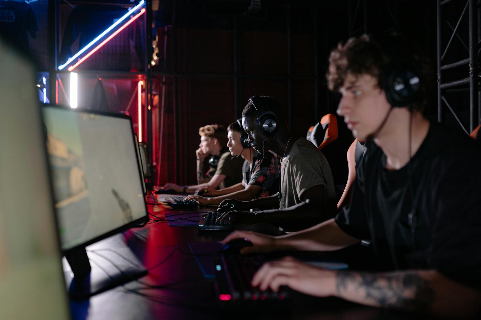 A glowing gaming monitor screen in a dark room suggesting intense focus