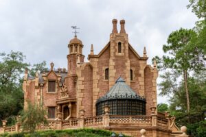 Dark, atmospheric haunted mansion exterior at night suggesting ghost adventure themes