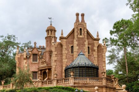 Dark, atmospheric haunted mansion exterior at night suggesting ghost adventure themes