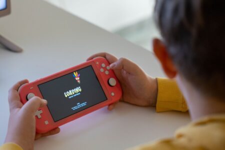 Person holding a handheld gaming console while playing a game