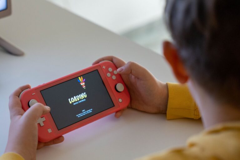 Person holding a handheld gaming console while playing a game