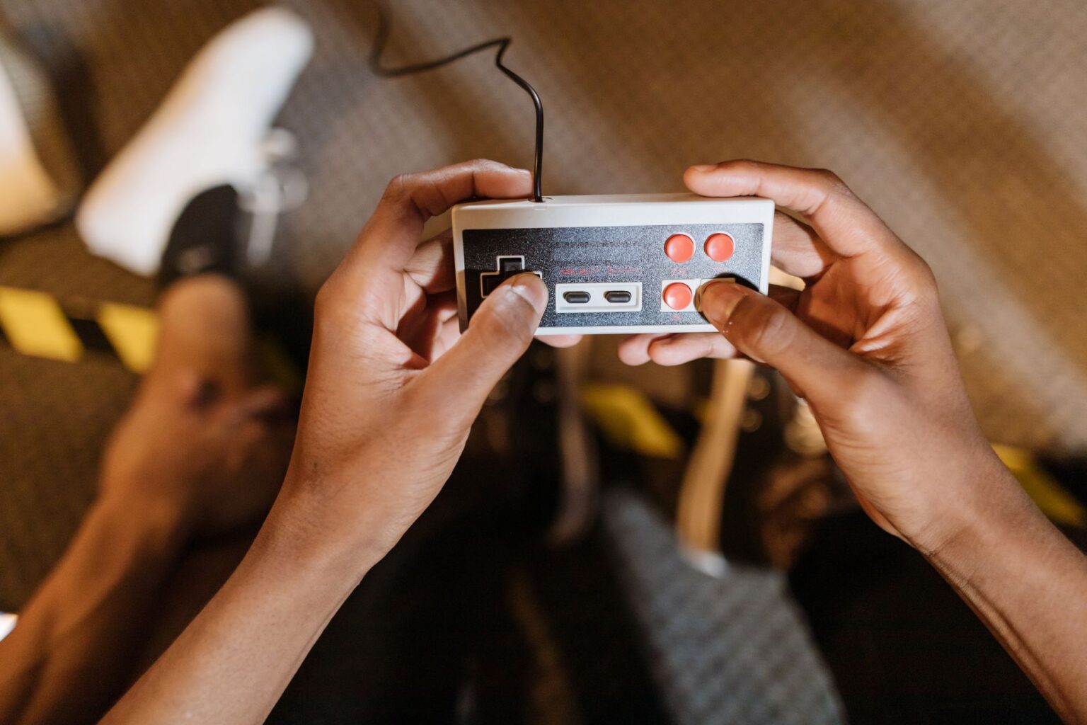 A game controller resting near a TV screen showing a colorful strategy game environment