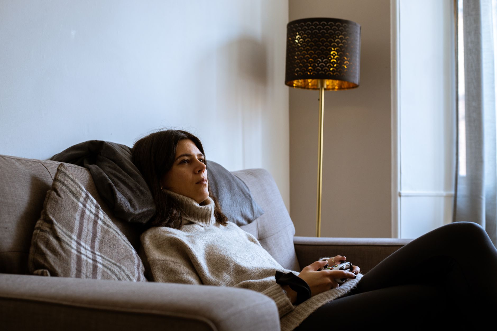 Two people playing video games together on a couch in a living room