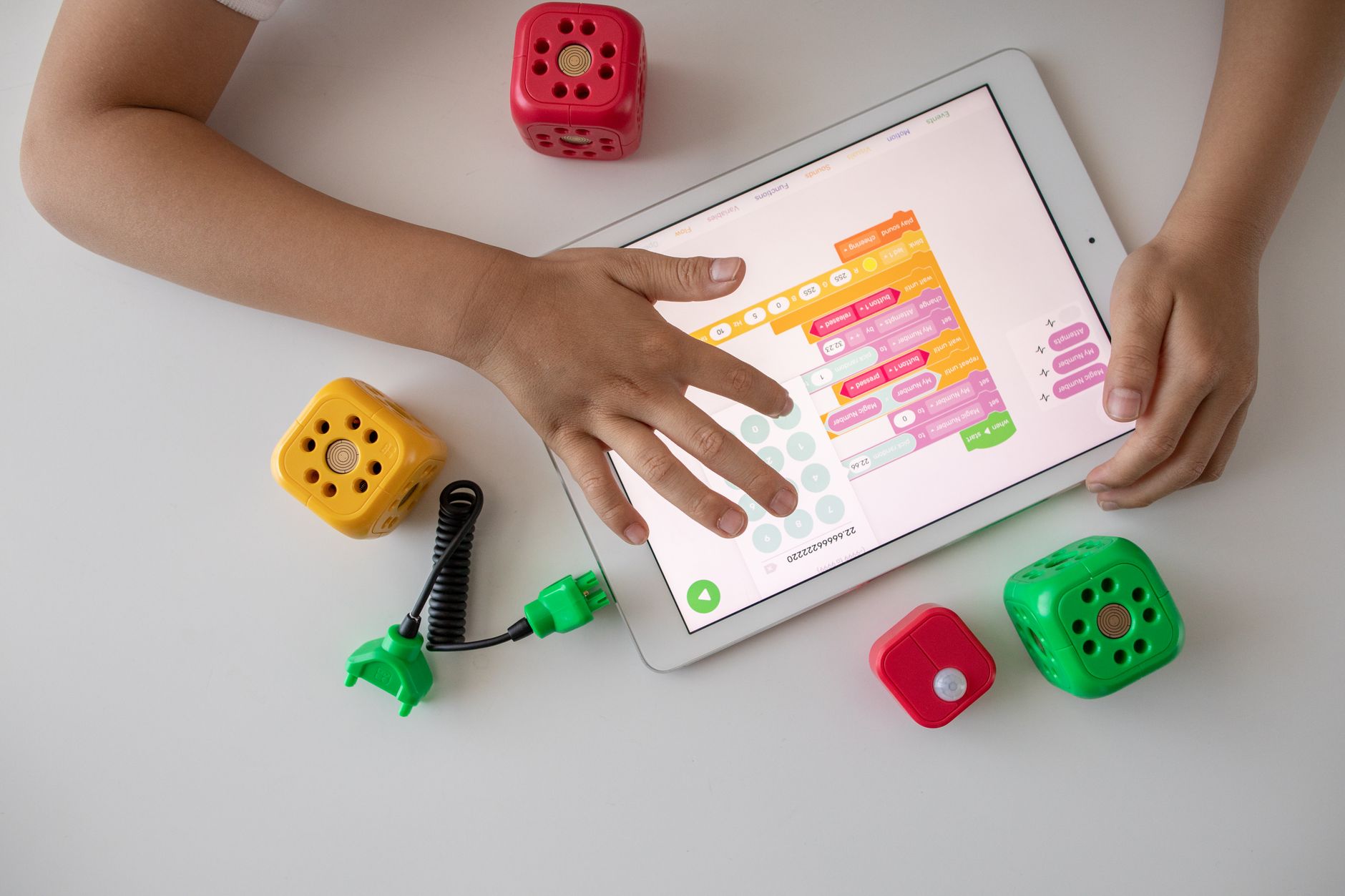 Young child using a digital device with a parent nearby