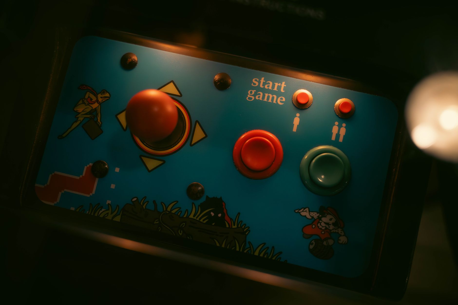 Classic arcade machines lit up in a dimly lit retro gaming room