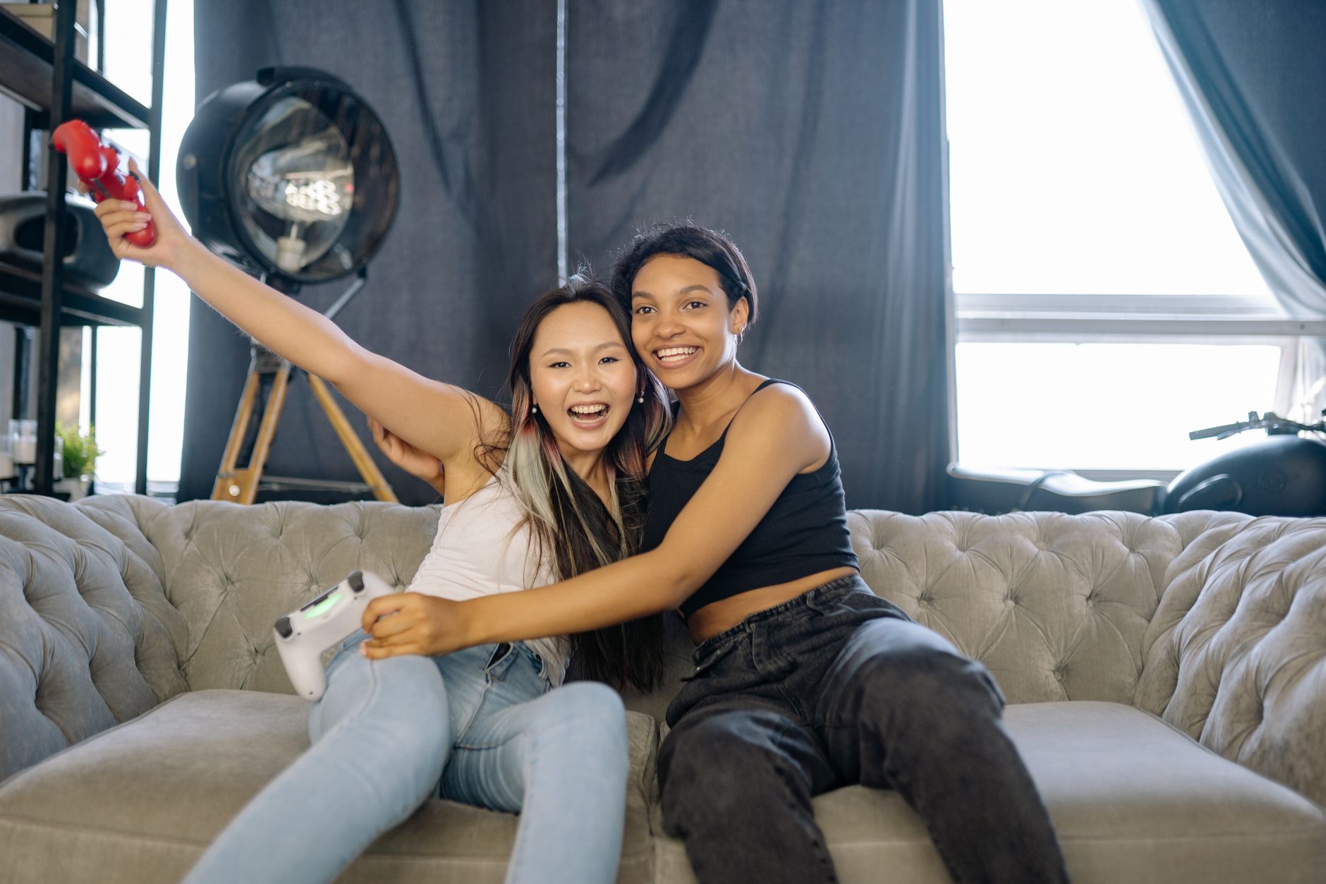 Two people sitting together playing video games on a couch illustrating cooperative multiplayer appeal