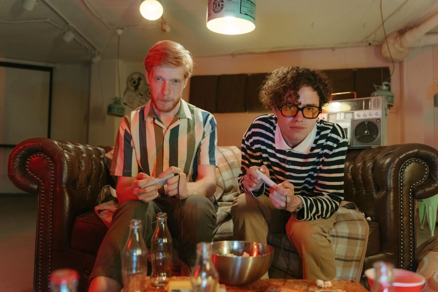 Two friends playing video games together on a couch, representing multiplayer gaming nostalgia