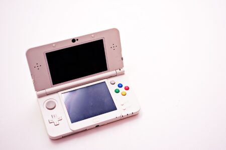 Person playing a handheld gaming console on a couch during a casual session